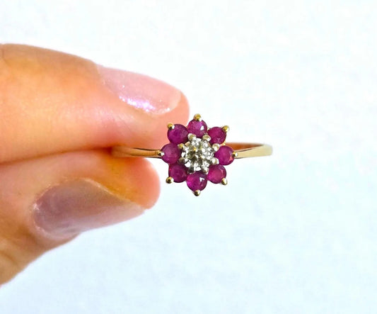 10k yellow gold flower ring with eight natural red-pink rubies surrounding a central natural diamond, size 6.5.
